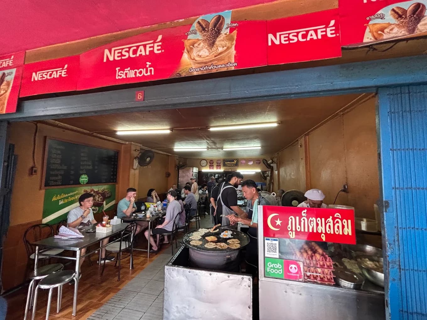 Frying fresh crispy rotis over the charcoal griddle in Phuket Old Town