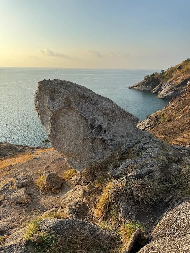 Scenic coastal trail climbing along the rocky headland past Nai Harn